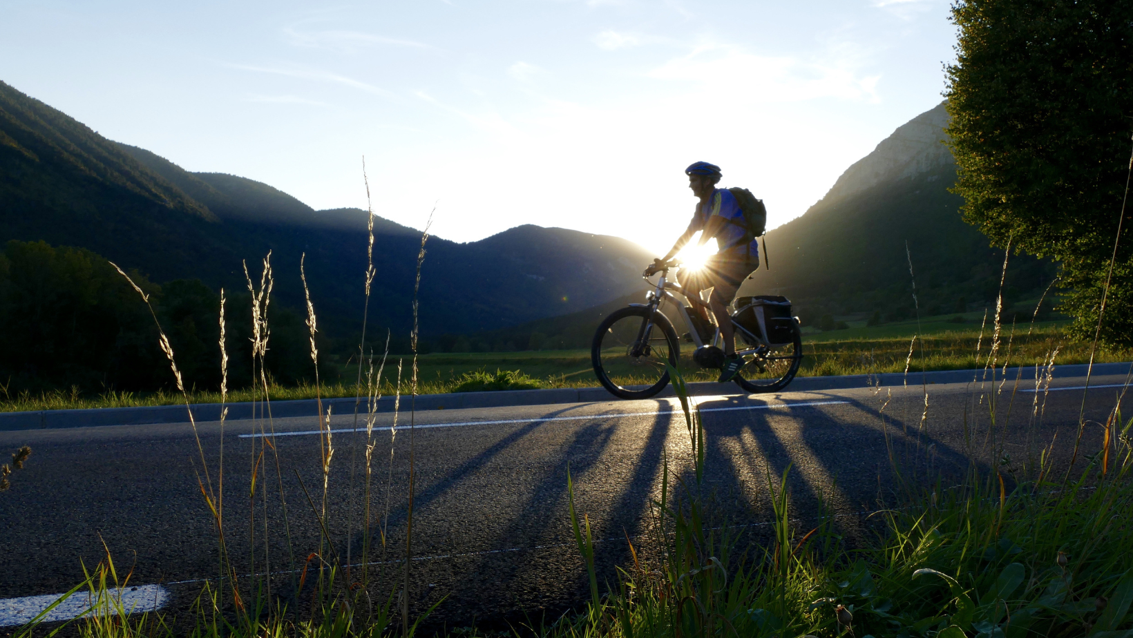 homme en vélo électrique devant les montagnes